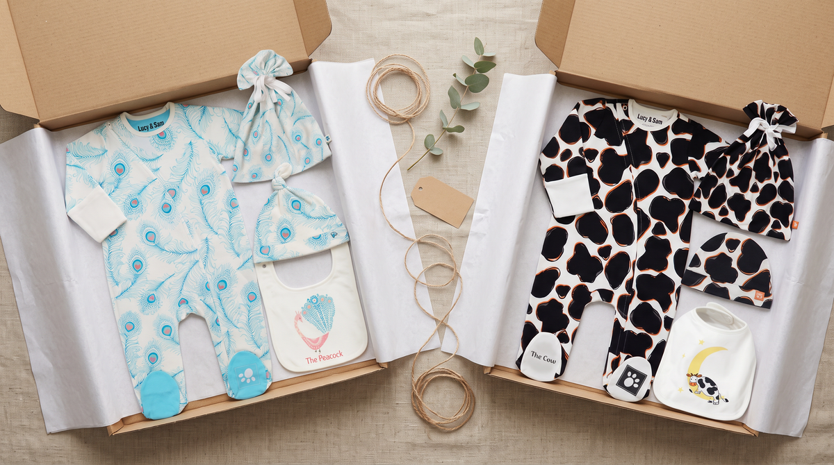 Peacock White and Cow organic cotton baby bundles in kraft gift boxes